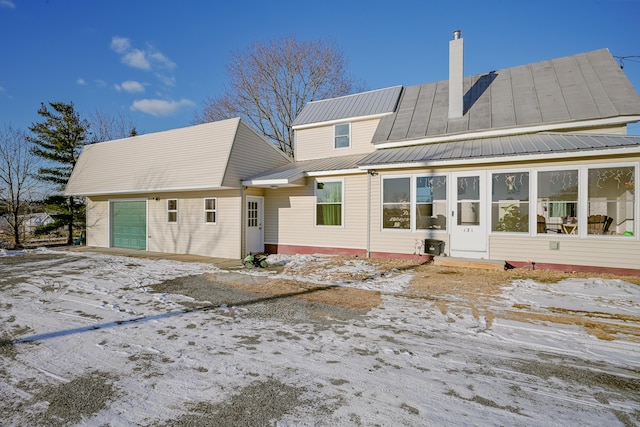 snow covered property with a garage