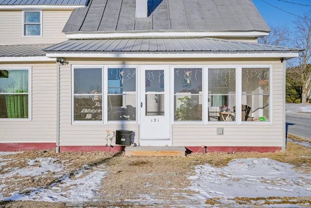 snow covered property featuring a sunroom