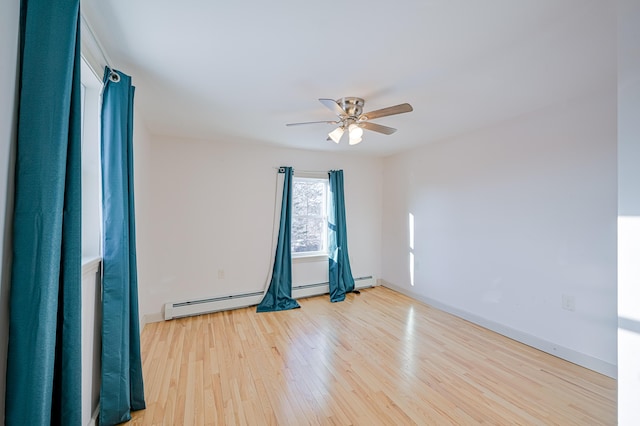 empty room with ceiling fan, light hardwood / wood-style floors, and a baseboard heating unit