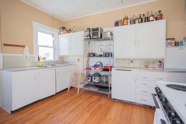 kitchen featuring white range with electric stovetop, light hardwood / wood-style floors, sink, and white cabinets