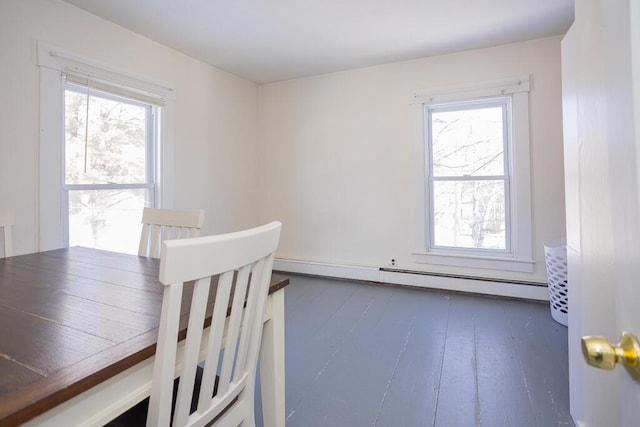 dining space featuring dark wood-type flooring, a baseboard radiator, and a wealth of natural light