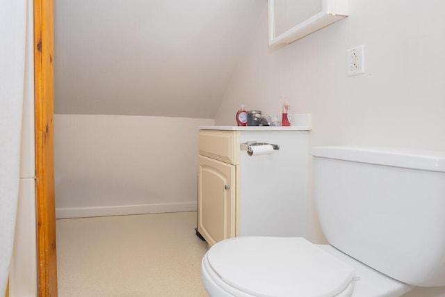 bathroom with vanity, vaulted ceiling, and toilet