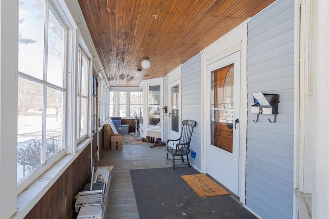 sunroom featuring a healthy amount of sunlight and wooden ceiling