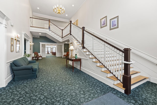 staircase featuring ornamental molding, carpet floors, a notable chandelier, and a towering ceiling