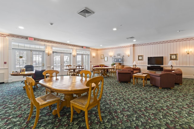 carpeted dining room featuring french doors