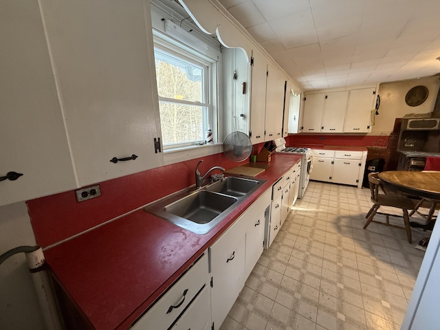 kitchen with white cabinetry, sink, and white gas stove