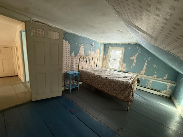 unfurnished bedroom featuring a baseboard radiator, wood-type flooring, and vaulted ceiling