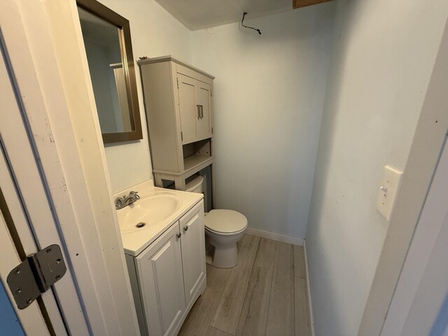 bathroom with vanity, hardwood / wood-style flooring, and toilet