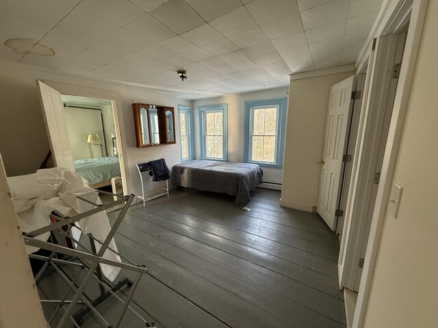 unfurnished bedroom featuring hardwood / wood-style flooring and baseboard heating