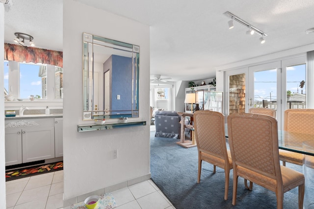 dining room featuring a ceiling fan, plenty of natural light, light tile patterned flooring, and light carpet