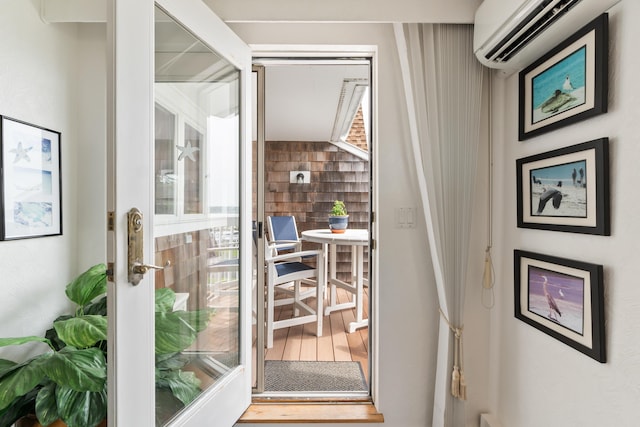 doorway with wood finished floors and a wall mounted AC