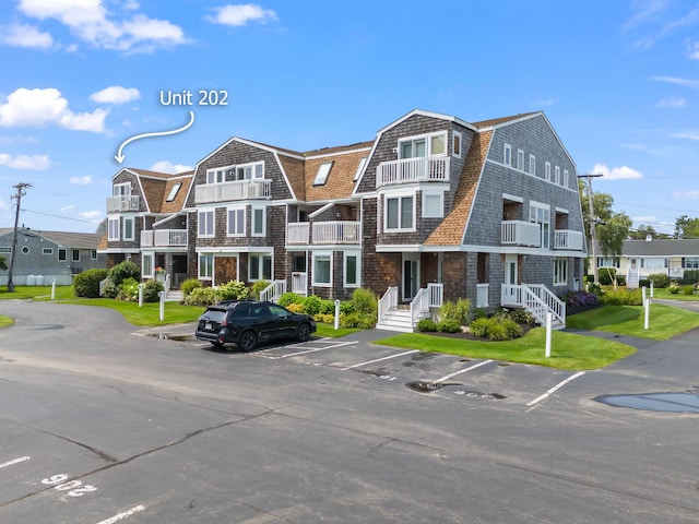 view of building exterior with uncovered parking and a residential view