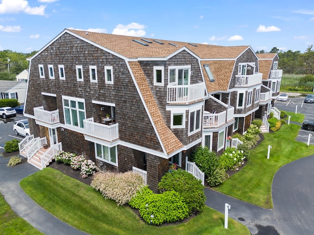 exterior space featuring a gambrel roof and a shingled roof