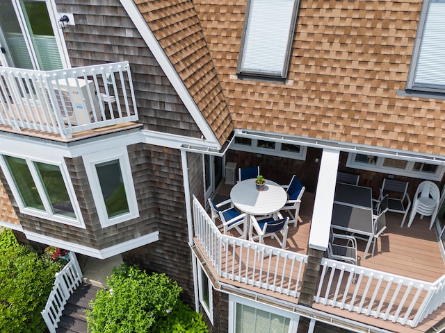 view of side of property with a balcony and roof with shingles