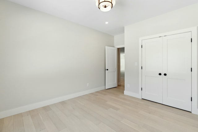 unfurnished bedroom with a closet and light hardwood / wood-style flooring