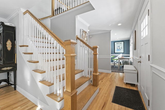 stairs featuring crown molding and hardwood / wood-style floors