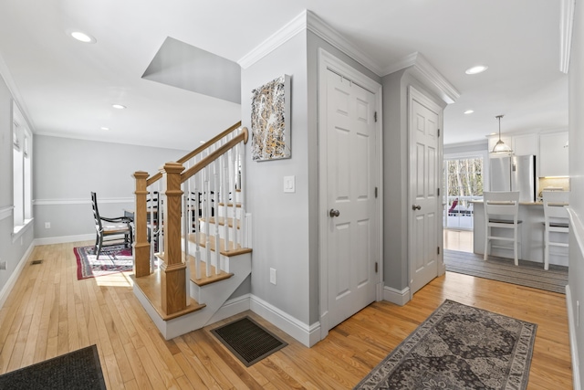 stairway featuring hardwood / wood-style flooring and crown molding