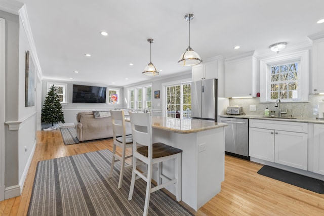 kitchen featuring white cabinetry, appliances with stainless steel finishes, sink, and a kitchen island