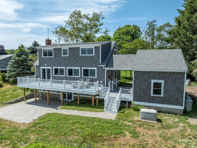 rear view of house featuring a patio, a deck, and a lawn