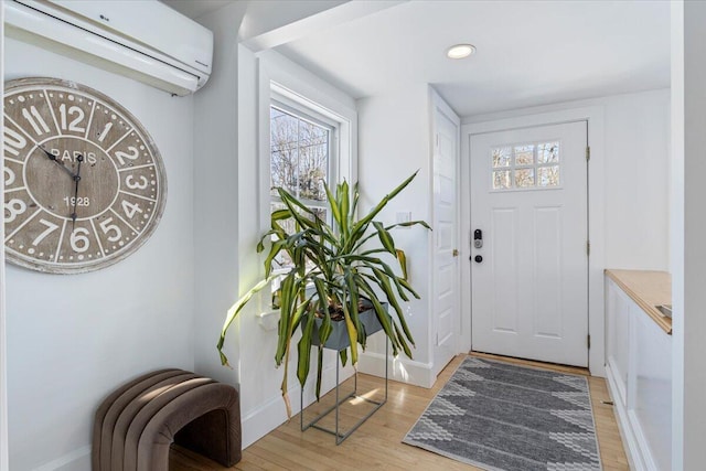 foyer featuring an AC wall unit and light wood-type flooring