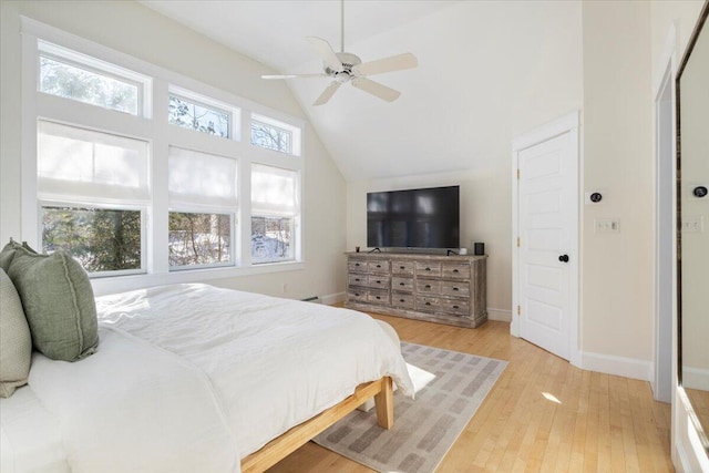 bedroom featuring multiple windows, lofted ceiling, ceiling fan, and light hardwood / wood-style floors