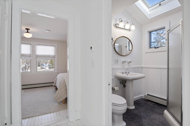 bathroom featuring tile patterned flooring, toilet, vaulted ceiling with skylight, and baseboard heating