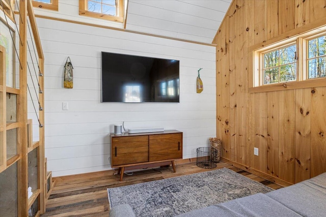 bedroom featuring dark wood-type flooring, vaulted ceiling, and wood walls