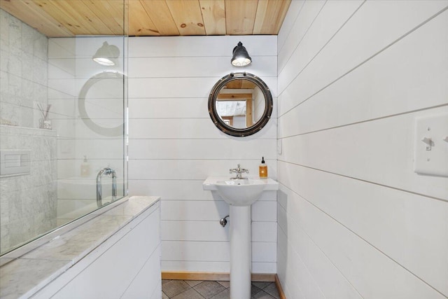 bathroom with wooden walls and wood ceiling