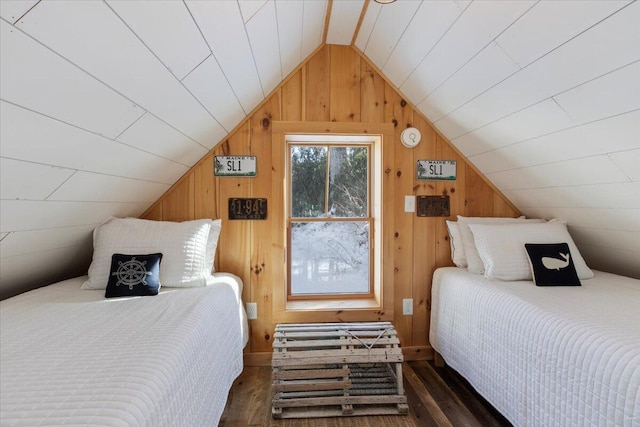 bedroom featuring lofted ceiling, wooden walls, and dark hardwood / wood-style floors