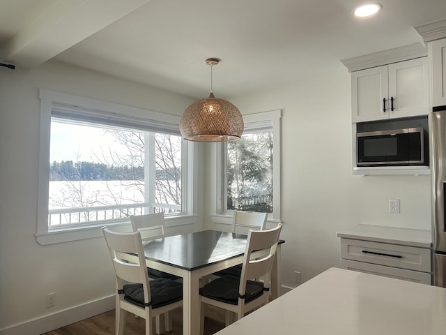 dining space with a healthy amount of sunlight and dark hardwood / wood-style floors