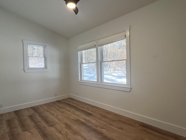 empty room featuring hardwood / wood-style flooring, lofted ceiling, and ceiling fan