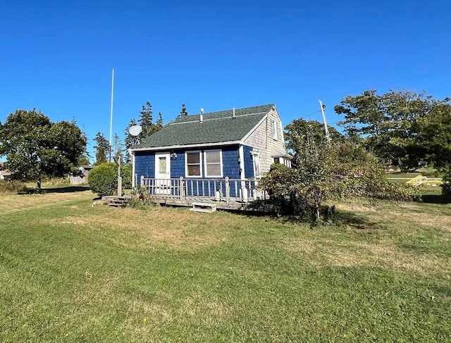 bungalow featuring a deck and a front lawn