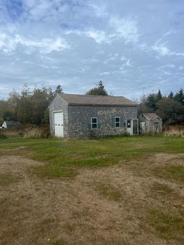 exterior space featuring a yard, an outdoor structure, and a garage