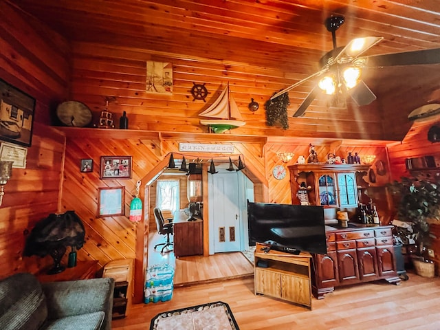 living room with wood ceiling, wooden walls, ceiling fan, and light wood-type flooring