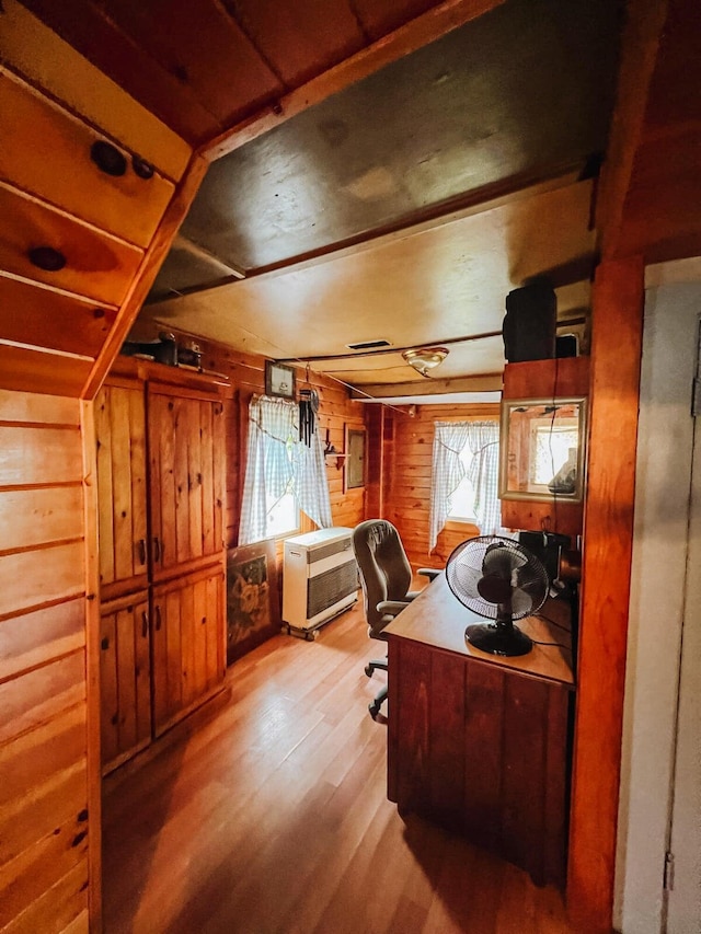 office space featuring hardwood / wood-style flooring, heating unit, and wood walls