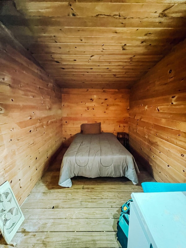 unfurnished bedroom with wood ceiling, wooden walls, and vaulted ceiling