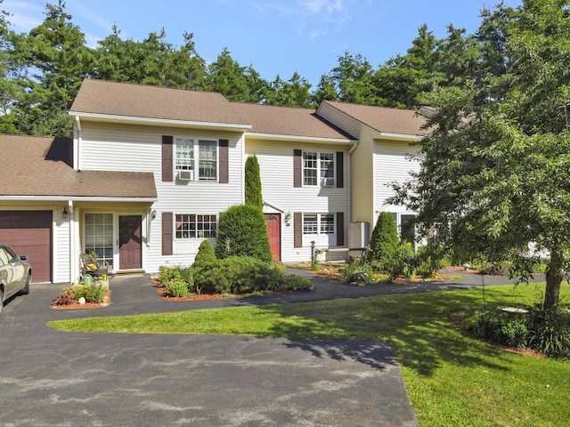 view of front facade featuring a front lawn, driveway, and an attached garage