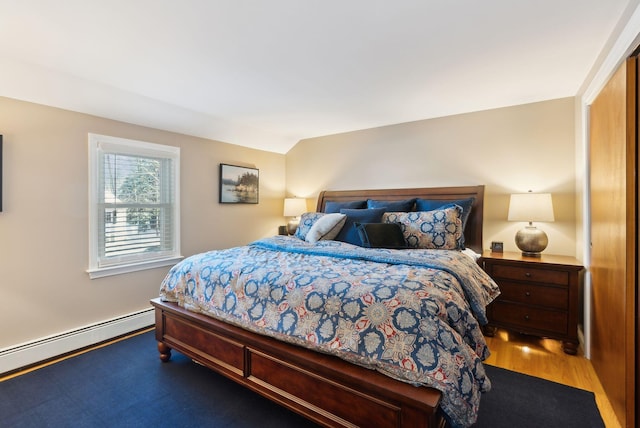 bedroom featuring baseboard heating and hardwood / wood-style floors