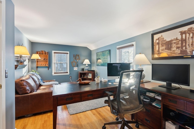 home office with vaulted ceiling and light hardwood / wood-style flooring