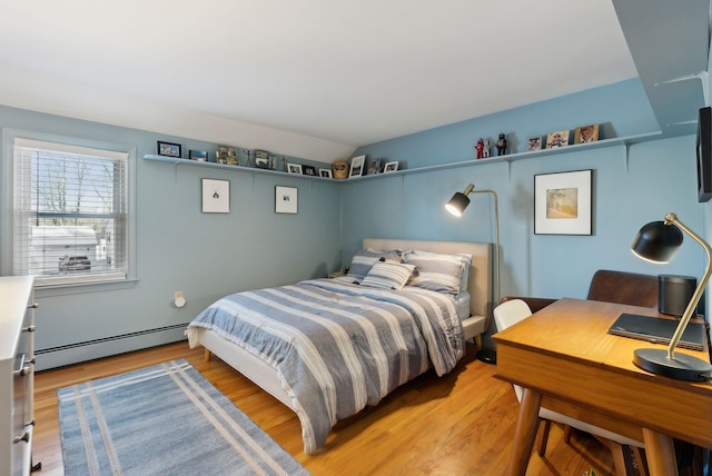 bedroom with a baseboard radiator and light hardwood / wood-style floors