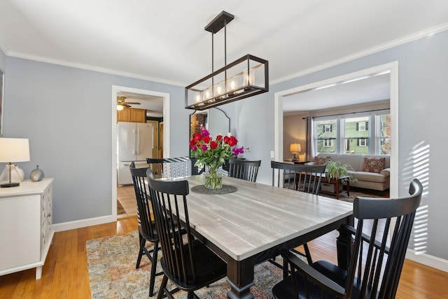 dining room featuring ornamental molding and light hardwood / wood-style floors