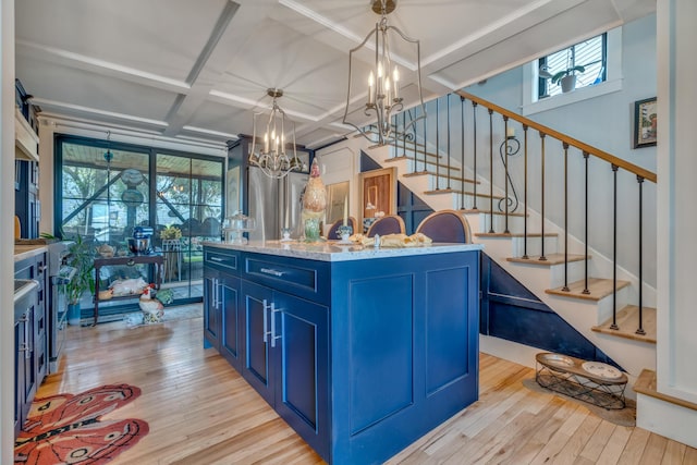 54 Webhannet Dr, Wells, ME 04090 - kitchen with blue cabinets, a chandelier, coffered ceiling, light wood-style floors, and a kitchen island