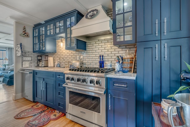 54 Webhannet Dr, Wells, ME 04090 - kitchen featuring appliances with stainless steel finishes, blue cabinetry, premium range hood, backsplash, and light wood-style flooring