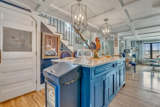 54 Webhannet Dr, Wells, ME 04090 - kitchen with blue cabinetry, coffered ceiling, light wood finished floors, a chandelier, and hanging light fixtures