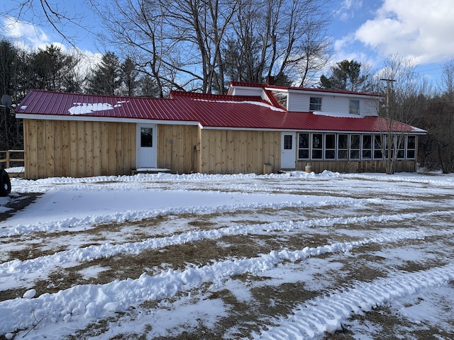 snow covered property featuring a sunroom