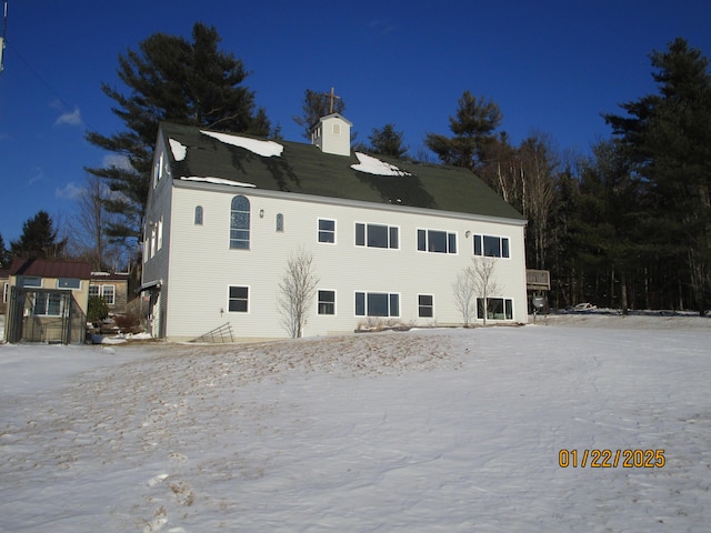 view of snow covered back of property