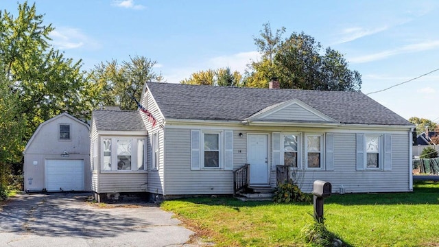 view of front of house with an outbuilding, a garage, and a front lawn