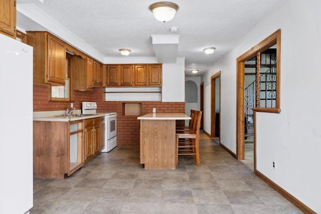 kitchen with tasteful backsplash, a kitchen breakfast bar, a center island, white appliances, and a textured ceiling