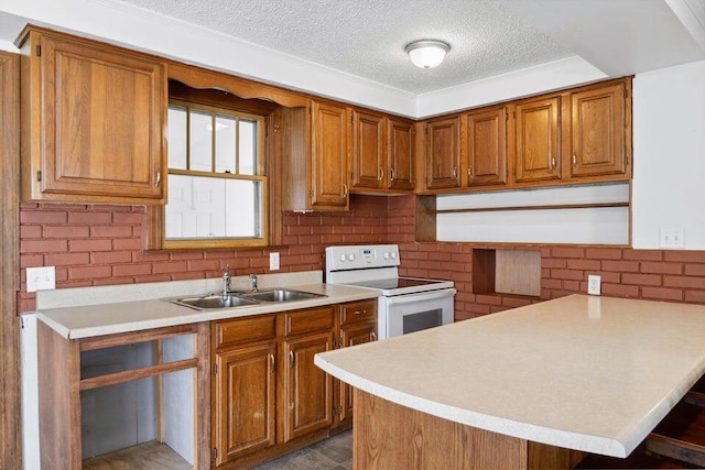 kitchen with white range with electric cooktop, sink, a breakfast bar area, kitchen peninsula, and a textured ceiling