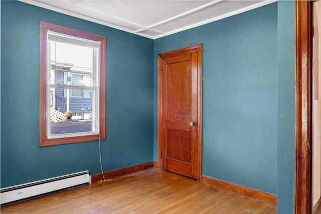 unfurnished room with a baseboard radiator and light hardwood / wood-style floors